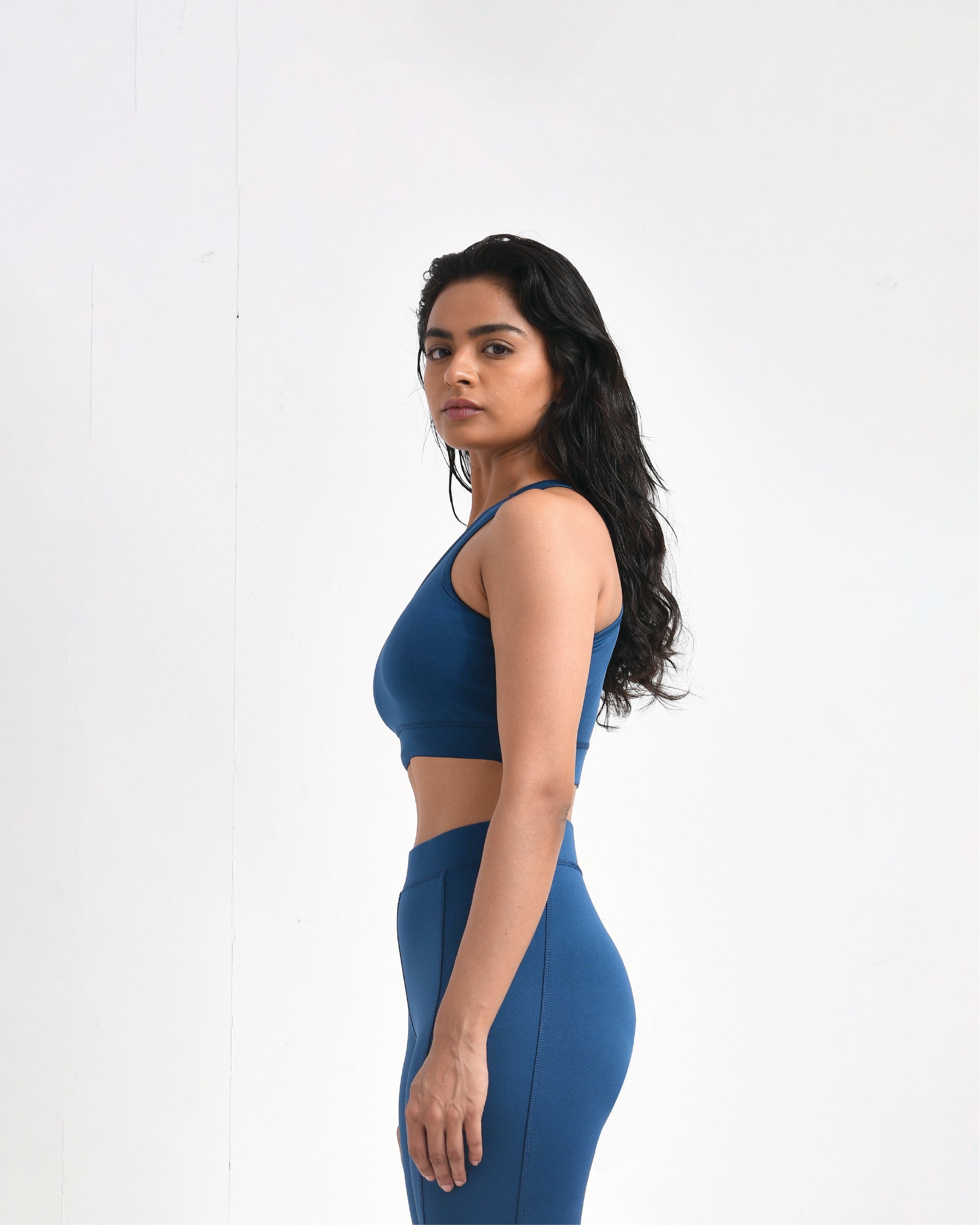 Side view of a blue sports bra for women by Six Point Three, featuring a logo on the chest, designed as a high-impact sports bra and perfect for gym workouts and active lifestyles.