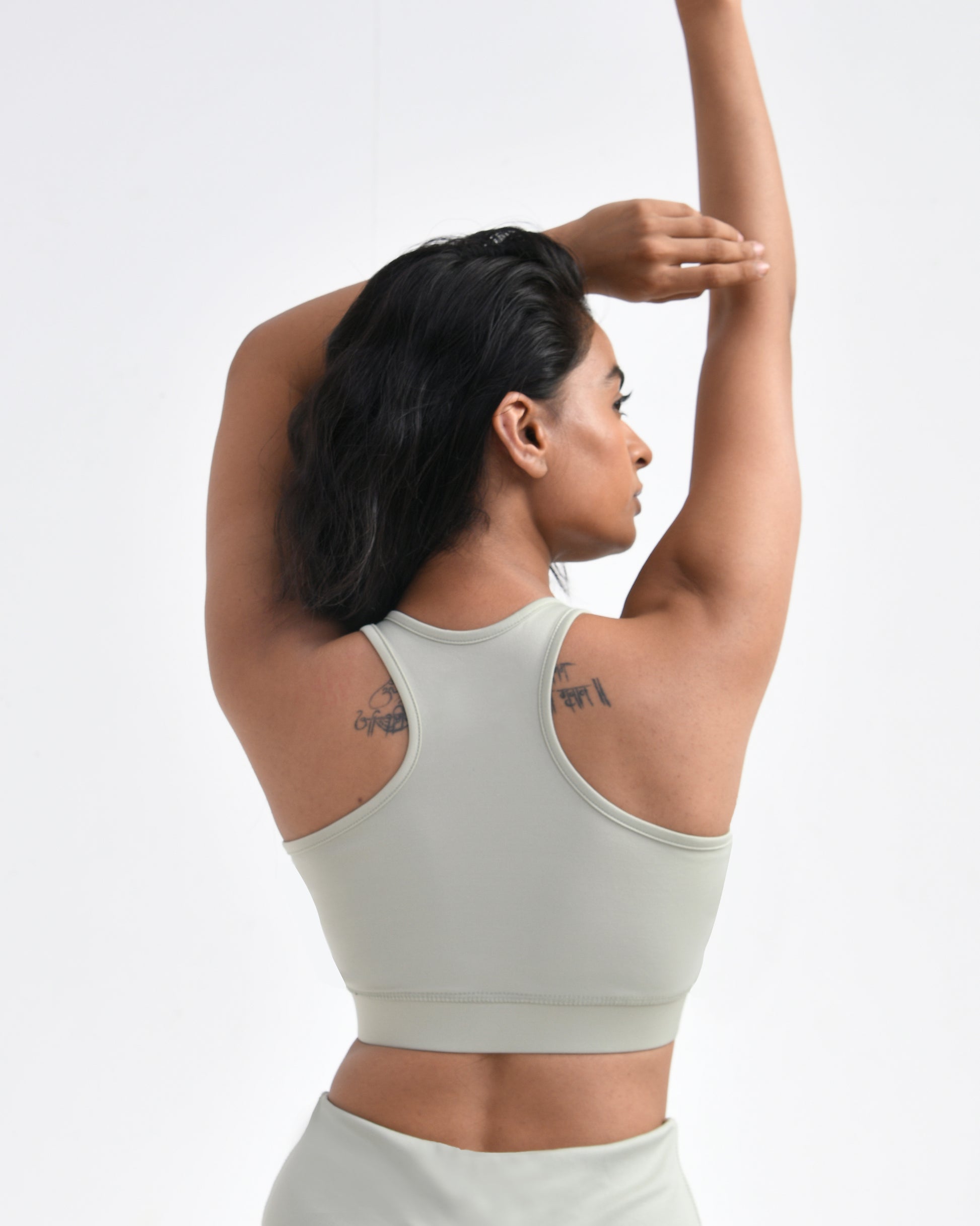 Women wearing a light green gym sports bra designed for high-intensity workouts, featuring a racerback style, ideal for comfortable and stylish gym wear.